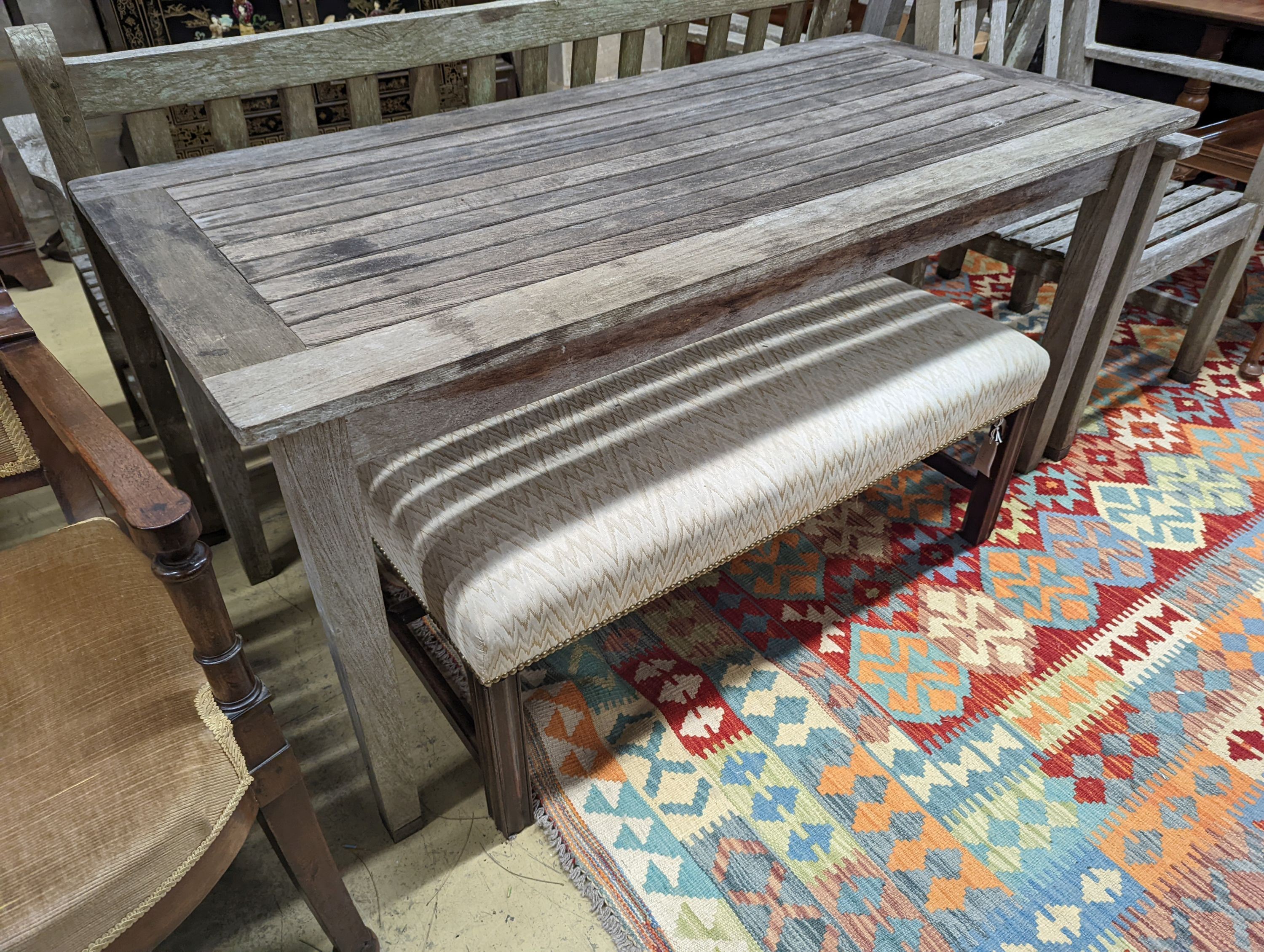 A Barlow type weathered teak garden suite, comprising rectangular table, length 149cm, depth 71cm, height 70cm, a bench and two armchairs